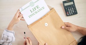 Woman removes document titled 'LIFE INSURANCE' from brown envelope