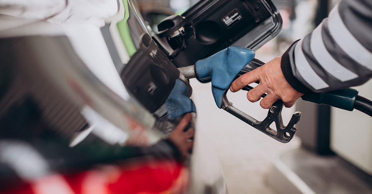 Close-up of a man placing a petrol dispenser into his car's fuel tank