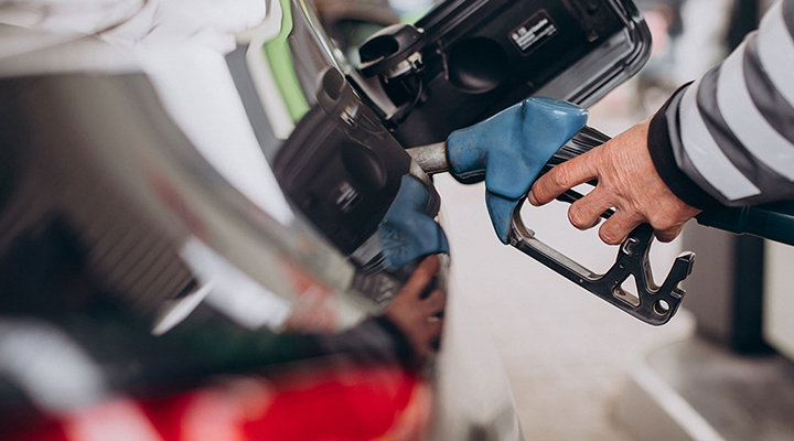 Close-up of a man placing a petrol dispenser into his car's fuel tank