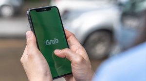 The Grab logo takes center stage as the app loads on a mobile phone, showing the wide reach of Grab Finance