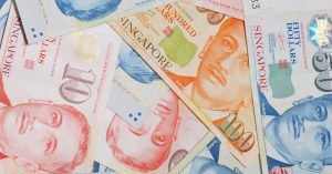 Different denominations of the Singapore currency lay scattered, representing the act of borrowing money